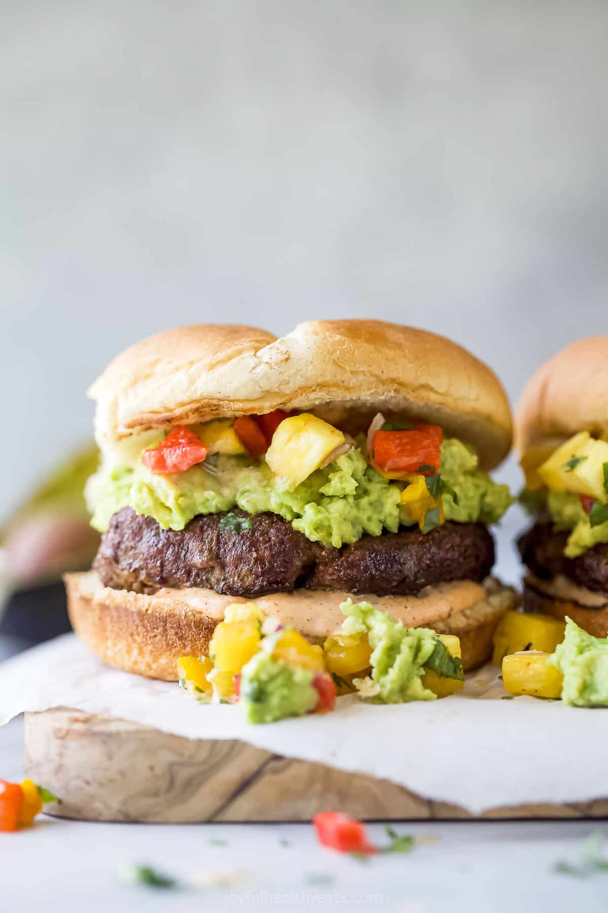 This 30-minute avocado burger is loaded with garlicky avocado mash and sweet pineapple pepper relish for a mouthwatering lunch. An avocado burger with avocado mash and pineapple relish.