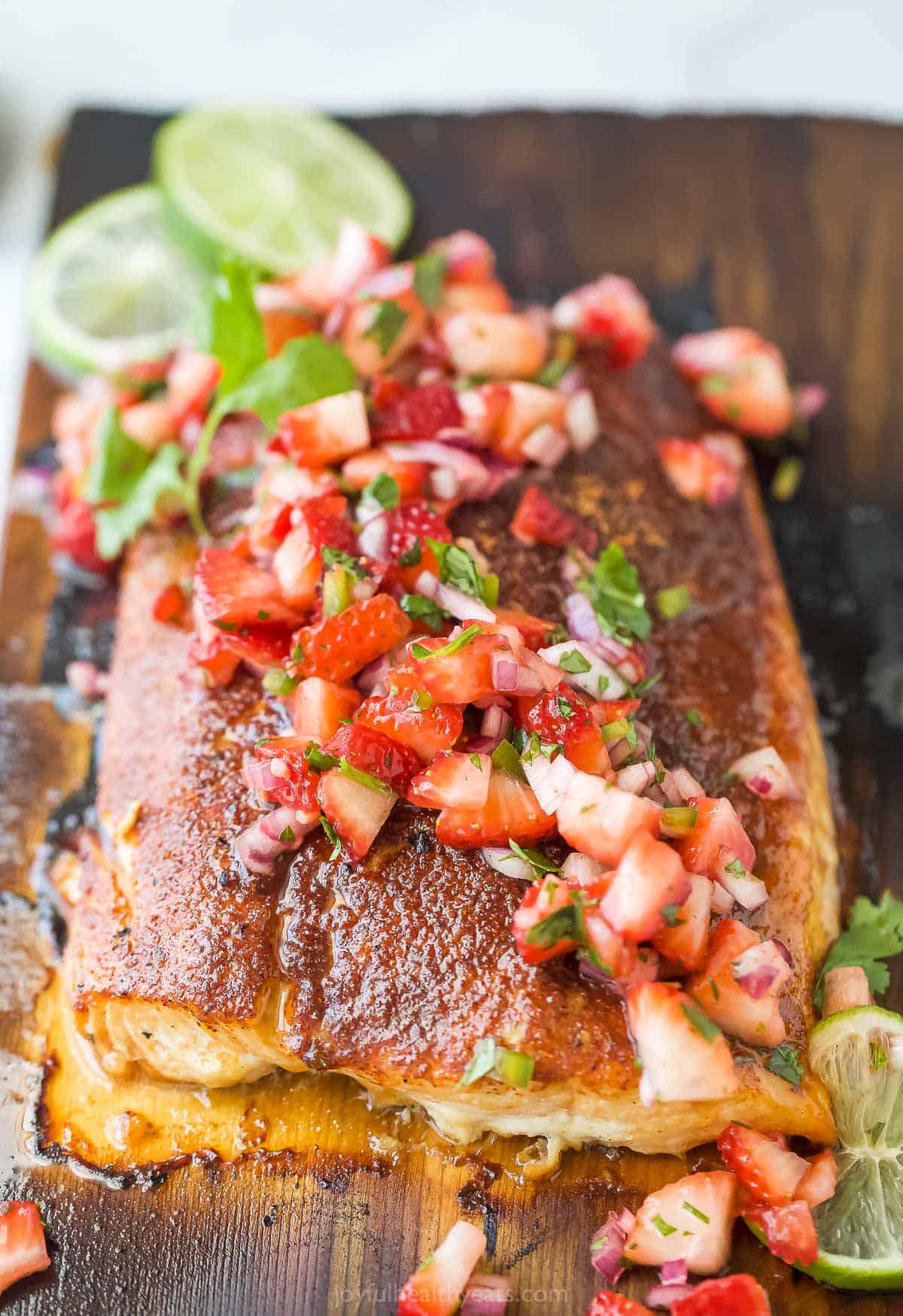 Close-up of cedar plank salmon with fruity salsa on top. 