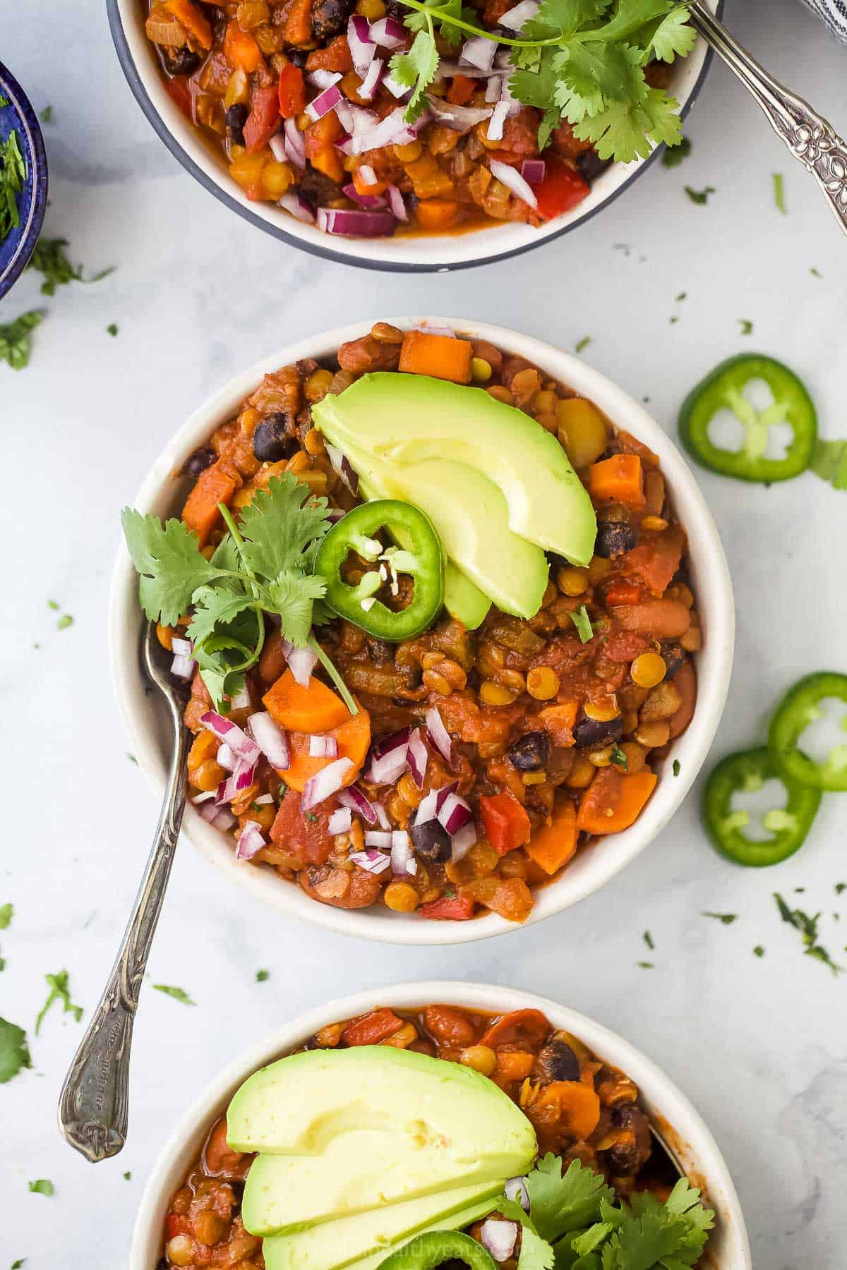 One-pot vegetarian lentil chili has a rich smoky flavor, is packed with hearty vegetables and beans, and is super easy to make! Vegetarian lentil chili in a bowl with toppings.
