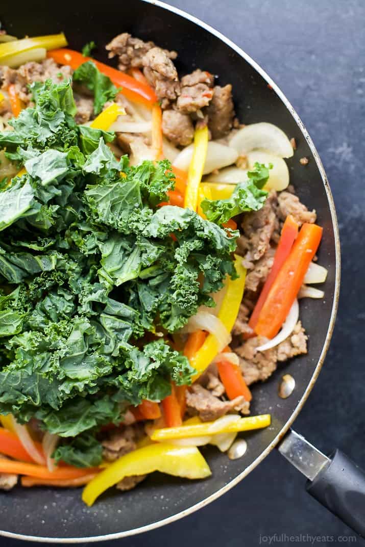 Ingredients for Creamy Kale Pepper & Sausage Pasta in a skillet