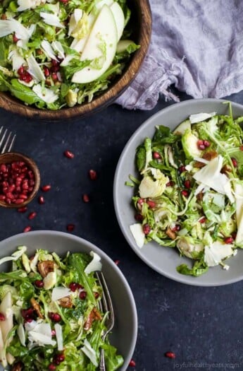 Shaved Brussel Sprout Salad filled with apples, pomegranate, candied pecans, and white cheddar cheese then tossed with a light Lemon Vinaigrette. This Brussel Sprout Salad is the perfect side dish for the holidays! | joyfulhealthyeats.com #glutenfree