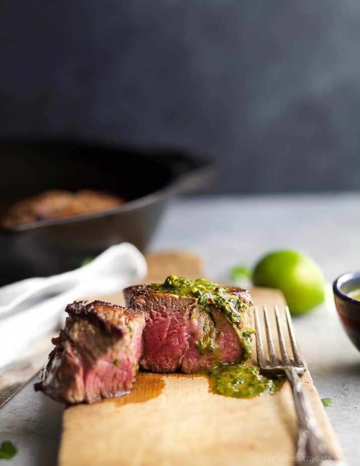 This 15 Minute Pan Seared Filet Mignon with Chimichurri is the ultimate date night dinner recipe. It's an easy recipe with incredible flavors. Filet Mignon with chimichurri sauce on a wooden board