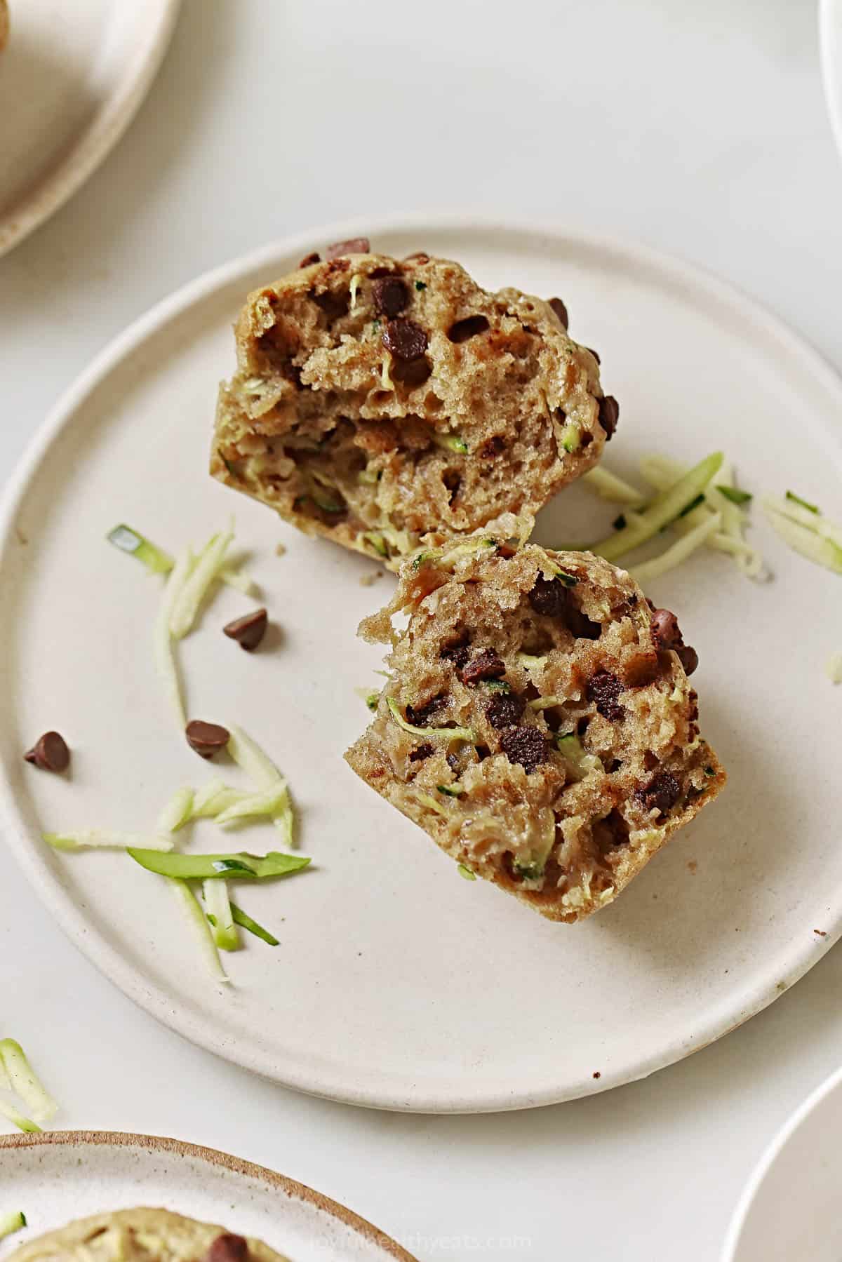 A halved zucchini chocolate chip muffin on a plate. 