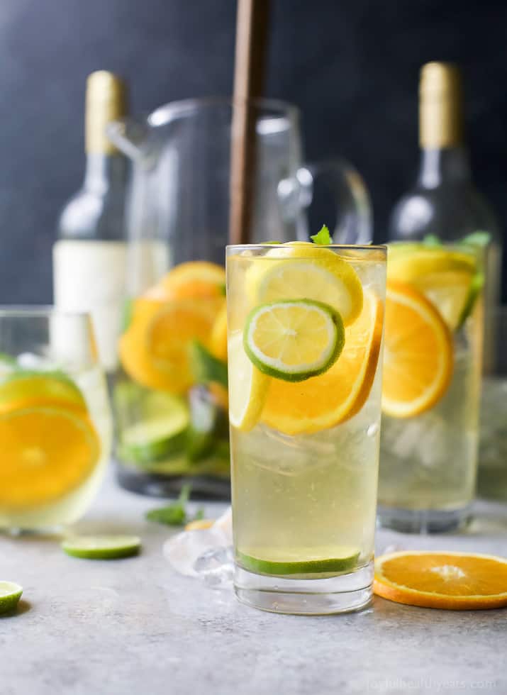 This simple white wine sangria recipe is flavored with lemon, lime & orange slices. This refreshing summer cocktail comes together in min! Tall glasses of Citrus White Wine Sangria with slices of citrus fruit