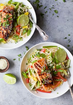 Two bowls of Easy Teriyaki Salmon served on a bed of Asian Noodles made with brown rice noodles, fresh veggies and a homemade Asian Sesame Dressing! | gluten free recipes