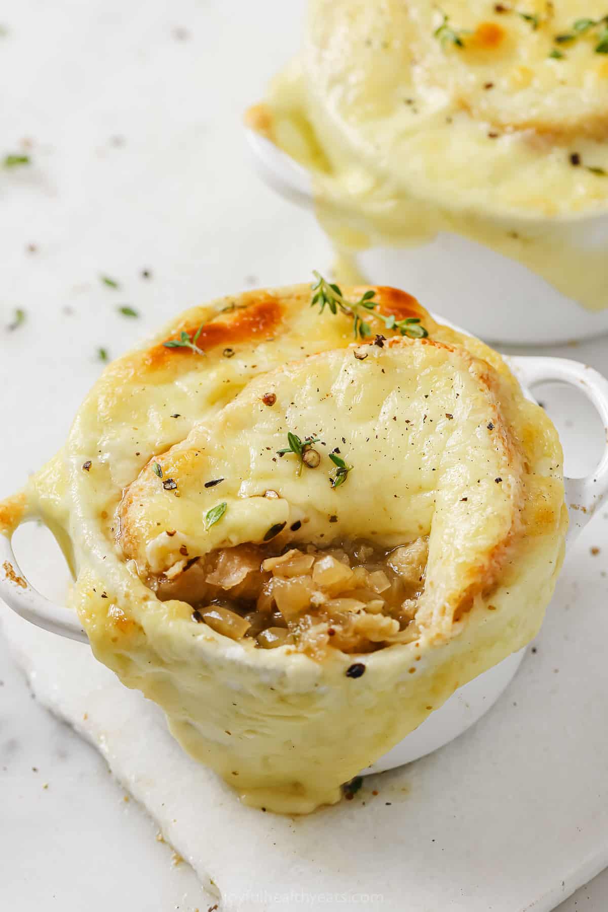 This comforting French onion soup recipe is filled with caramelized onions, a deep beef flavor, toasty bread, and lots of gooey cheese. French onion soup with melty cheese.