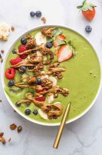 green smoothie bowl with fresh fruit and peanut butter drizzle