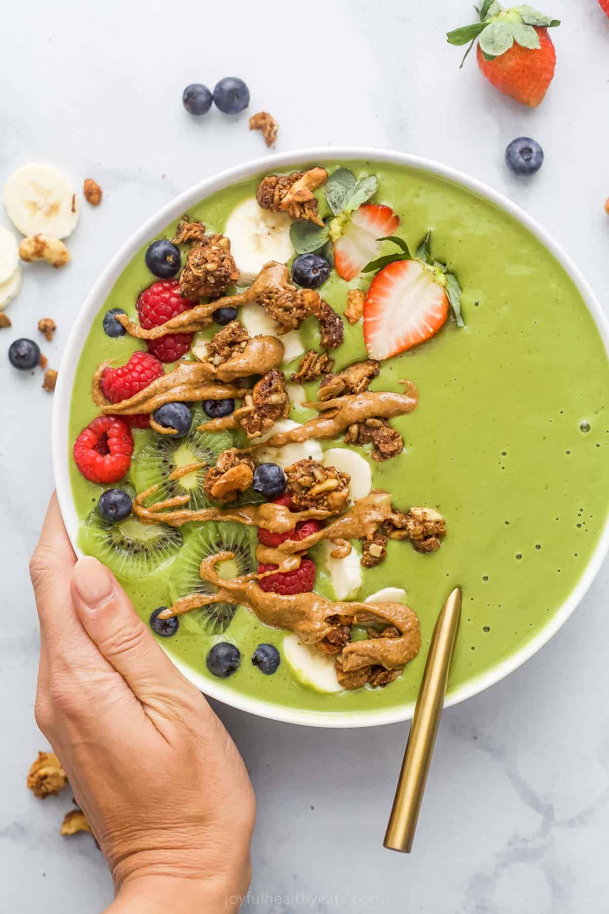 This Green Smoothie Bowl is loaded with spinach and fresh fruit for a breakfast that is quick, healthy, and easily customizable. green smoothie bowl with fresh fruit and peanut butter drizzle