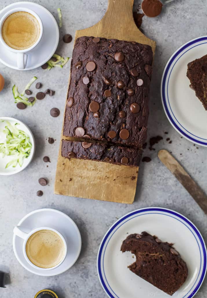 Whole chocolate zucchini bread on a wooden chopping board. 