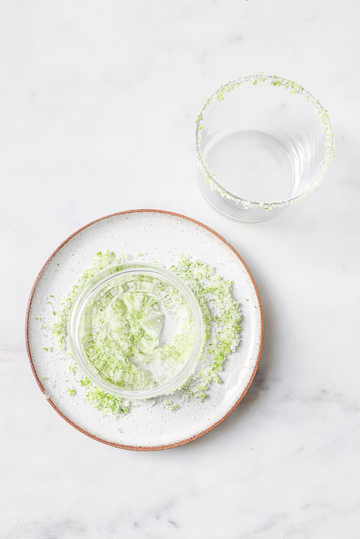 Adding the lime-sugar rim to a serving glass. 