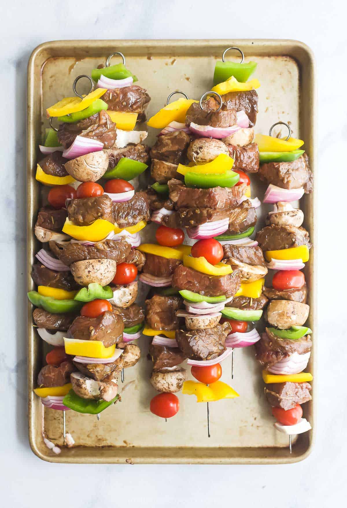 Cooked skewers on a baking sheet.