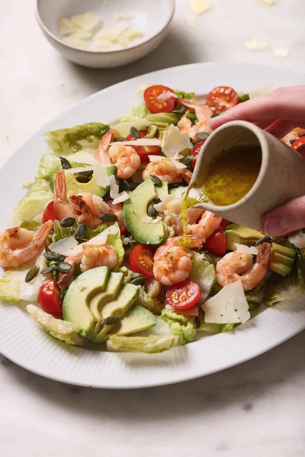 Pouring dressing over the salad. 