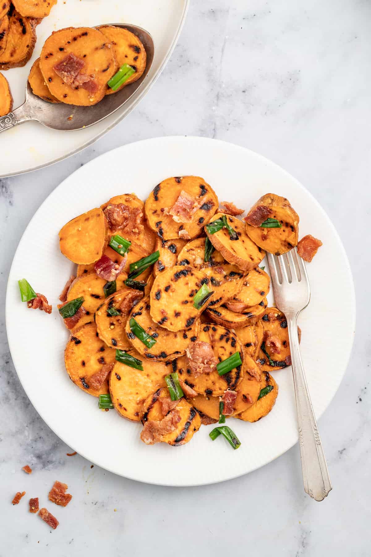 This 30-minute grilled sweet potato salad with bacon and honey mustard dressing is an easy side you'll be making on repeat this summer. Plate of grilled sweet potato salad.