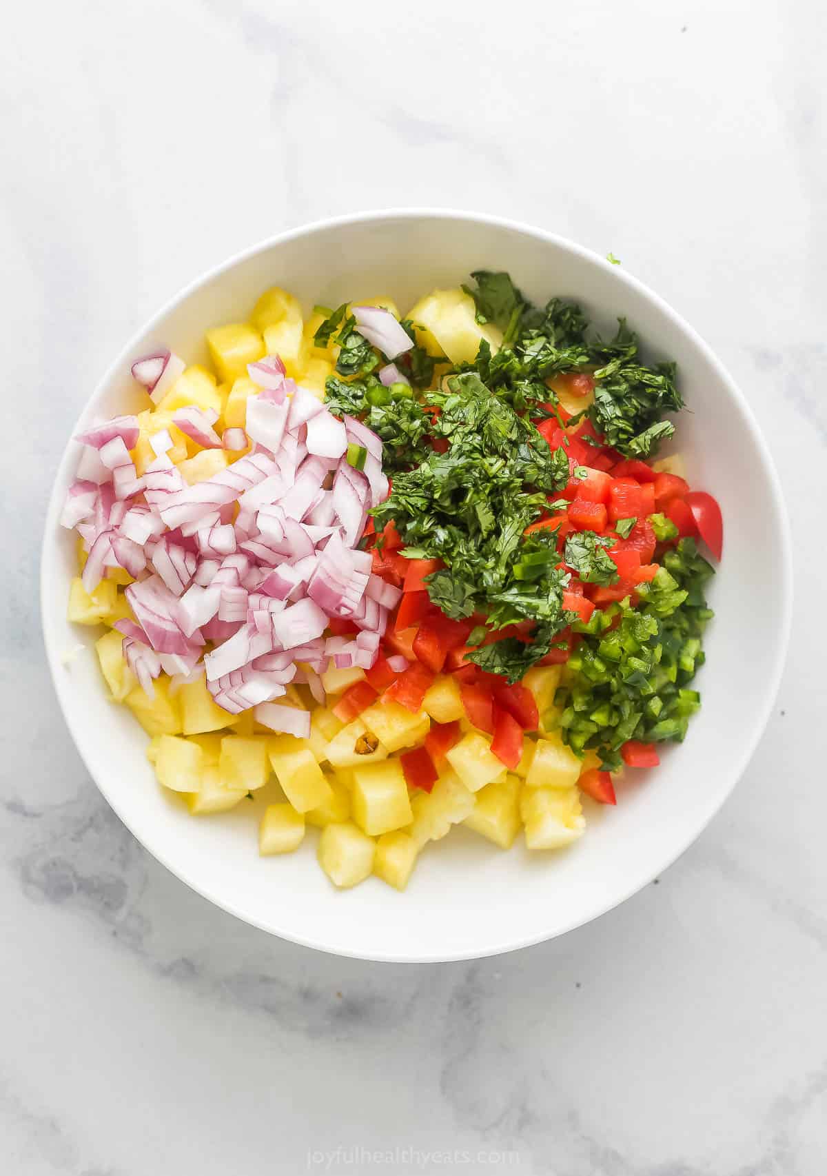 Adding the salsa ingredients to a bowl.