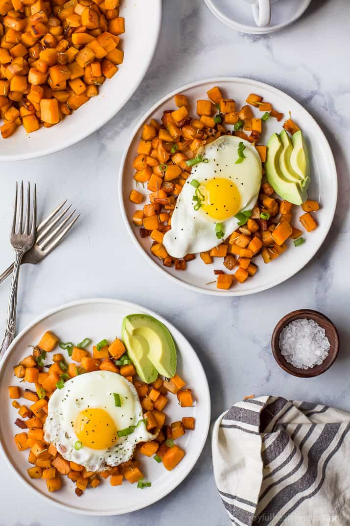 Two plates of sweet potatoes with eggs and creamy avocado.