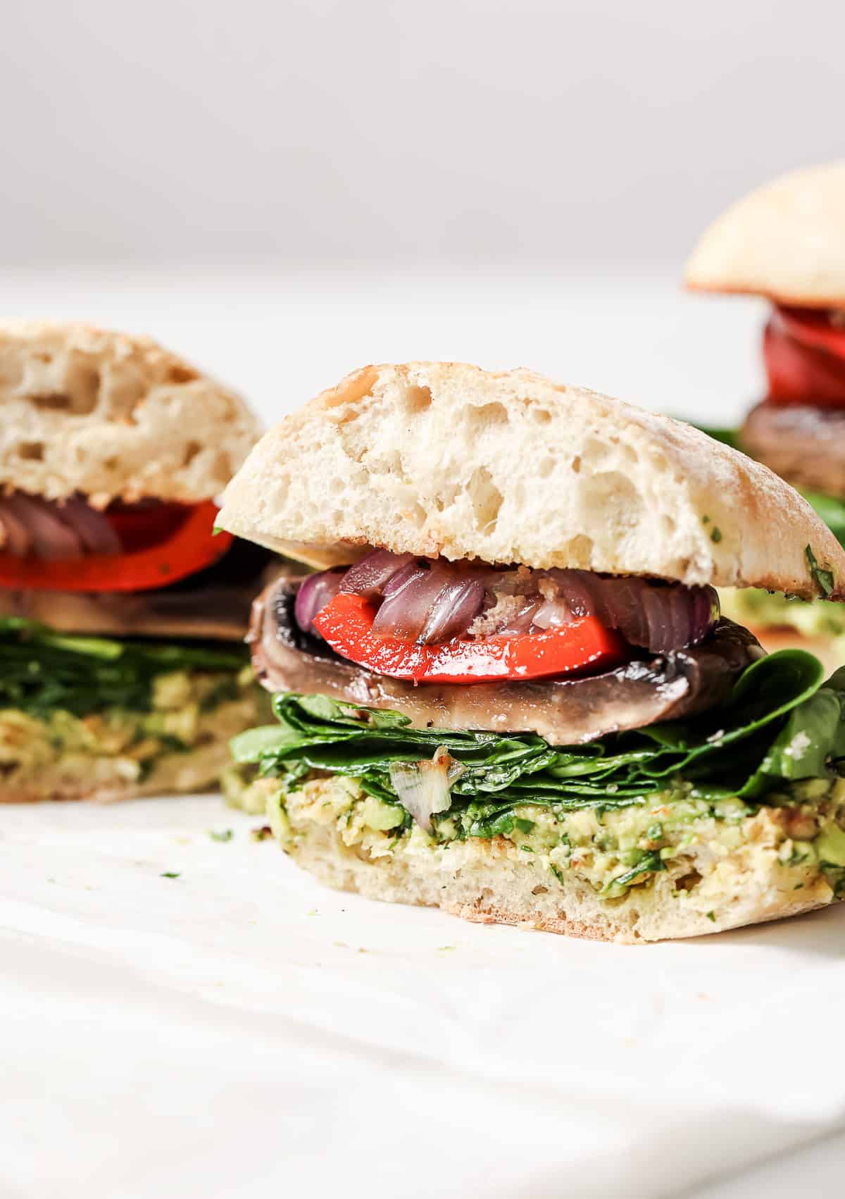 Close-up of the sliced portobello mushroom burger with grilled veggies. 