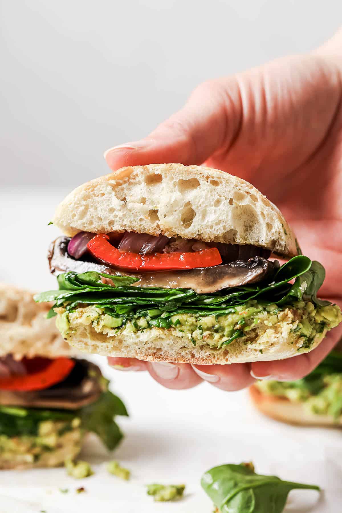 Close-up of layers in the mushroom portobello burger with cilantro-avocado chimichurri. 