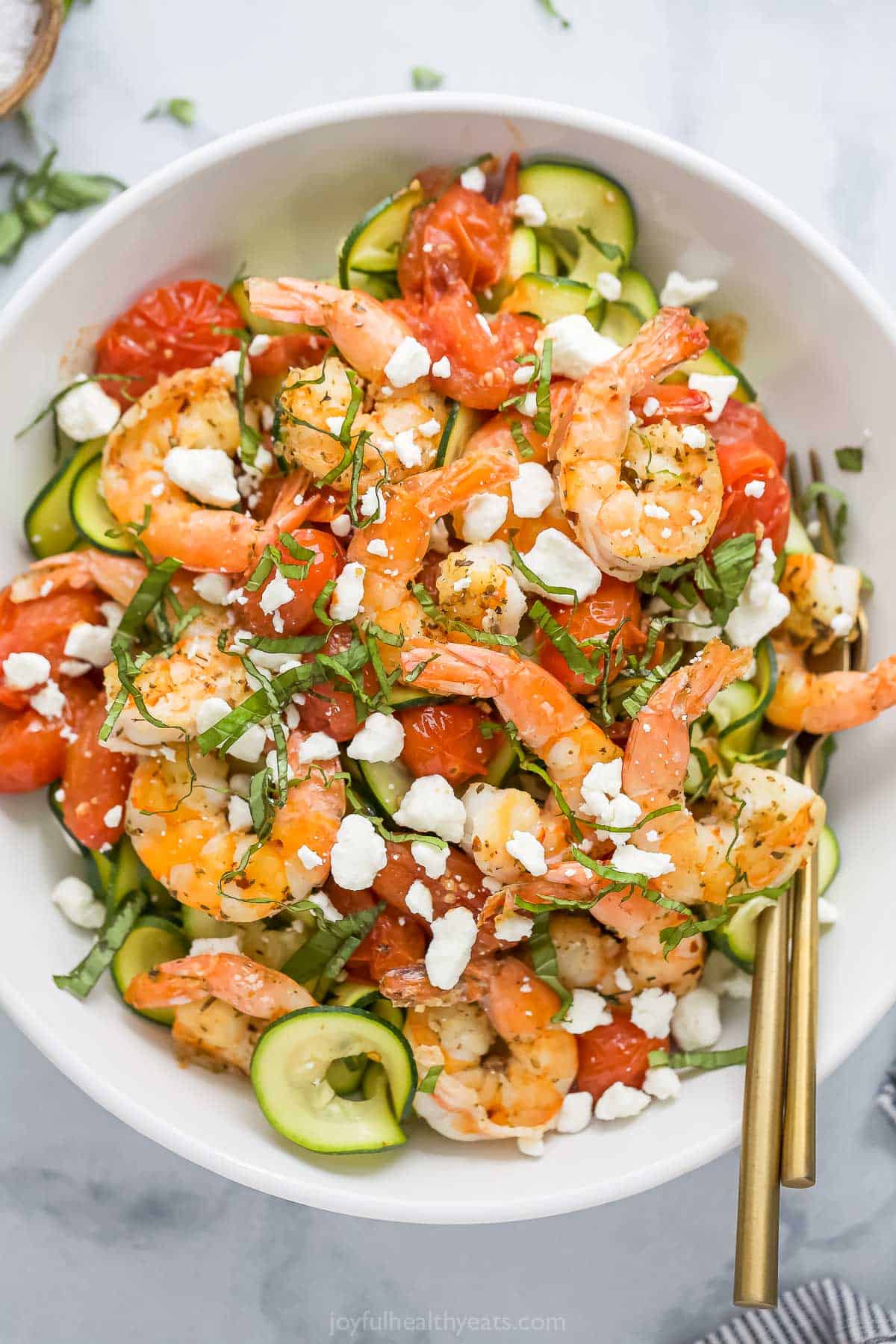 This 20-minute creamy shrimp pasta recipe is loaded with fresh zoodles, goat cheese, and garlicky cherry tomatoes for a light dinner. Bowl of creamy shrimp pasta with zoodles.