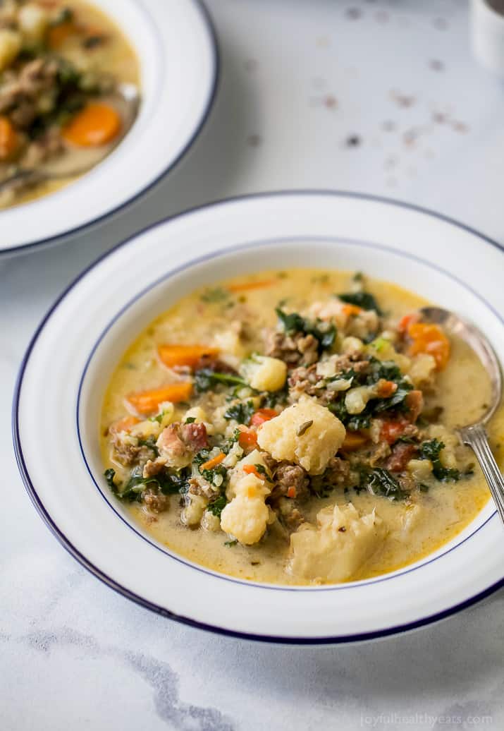 Homemade zuppa toscana with sausage, bacon, and veggies in a bowl. 
