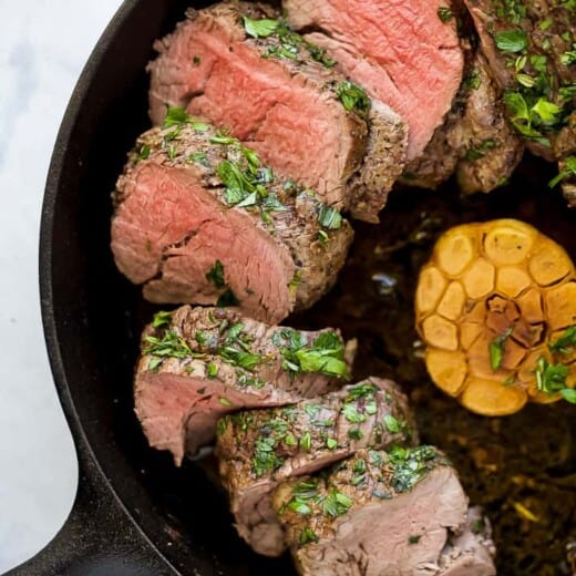 Juicy beef tenderloin with garlic in the skillet.