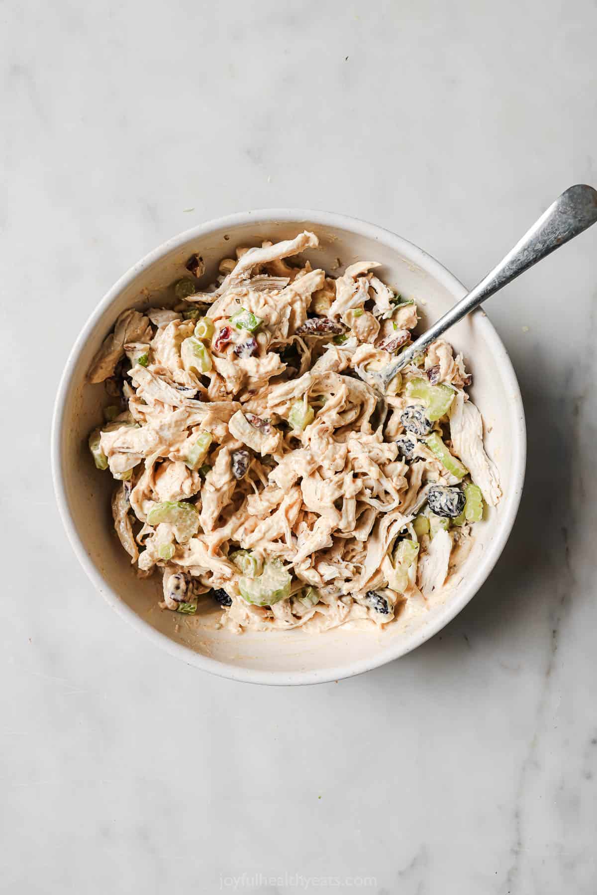 Bowl with tossed ingredients and dressing. 