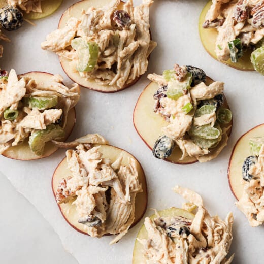 Landscape photo of cranberry chicken salad on apple slices.