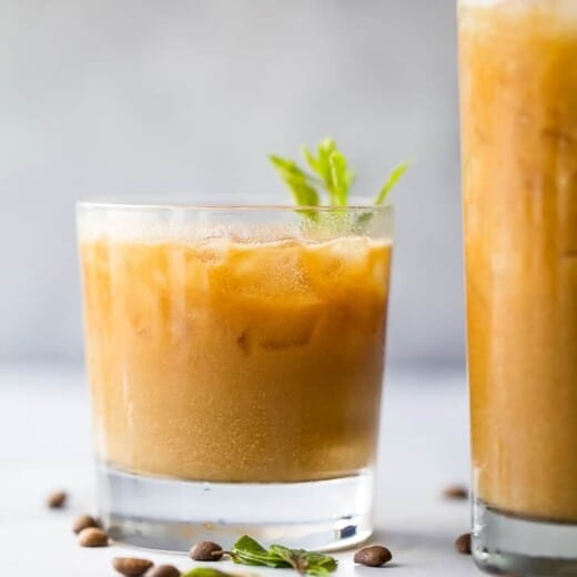 Small glass of Thai iced coffee set next to tall glass