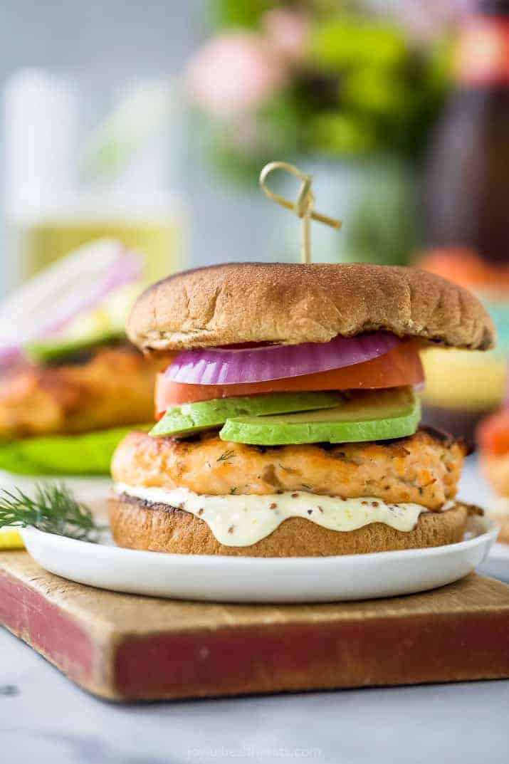 best grilled salmon burger topped with tomato, avocado, red onion and lemon garlic aioli