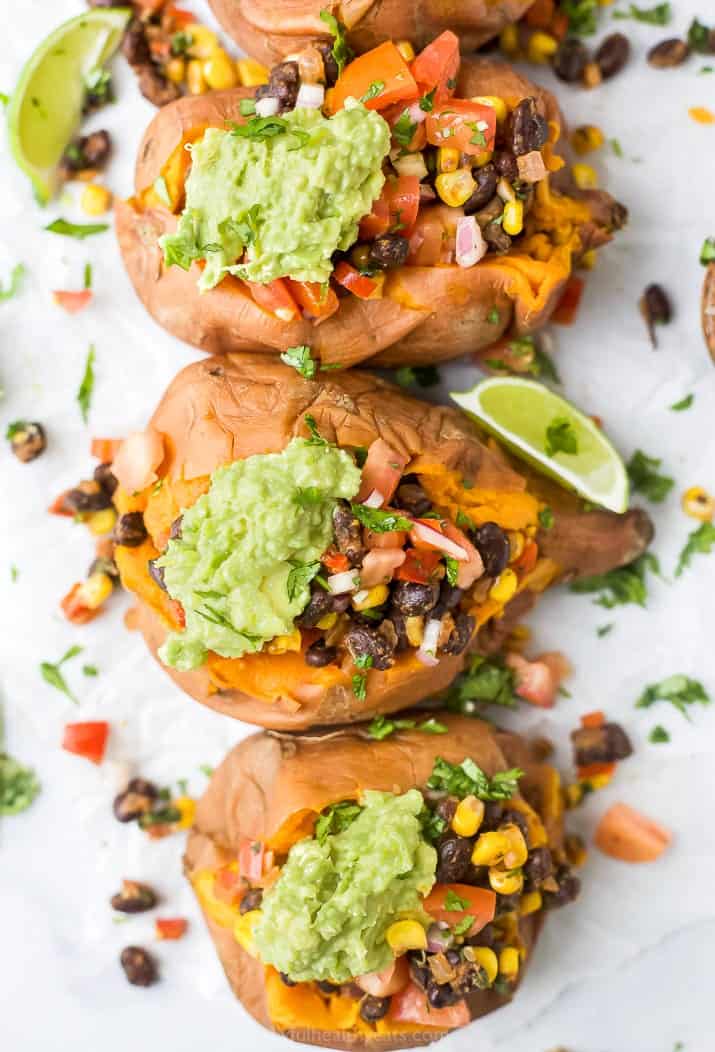 overhead photo of easy vegan black bean stuffed sweet potatoes with guacamole on top
