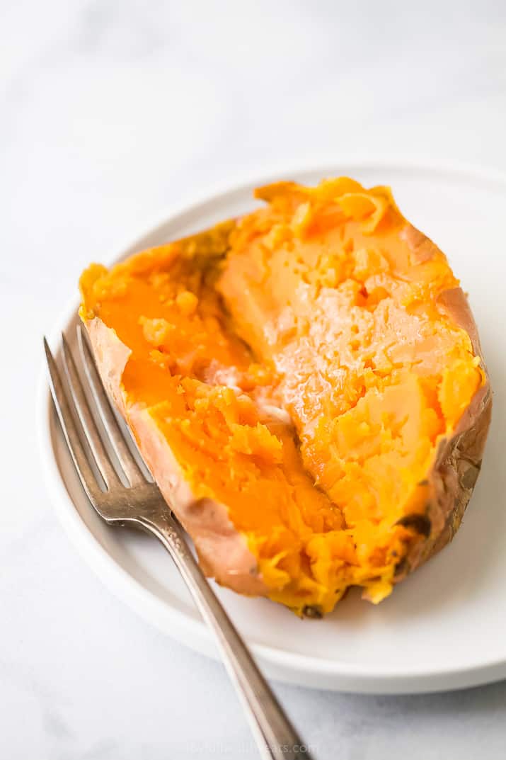 Make sweet potatoes in half the time it takes to bake/roast them. Use this easy method to get perfect instant pot sweet potatoes every time! Sweet potatoes cooked in an instant pot on a plate with butter and a fork.