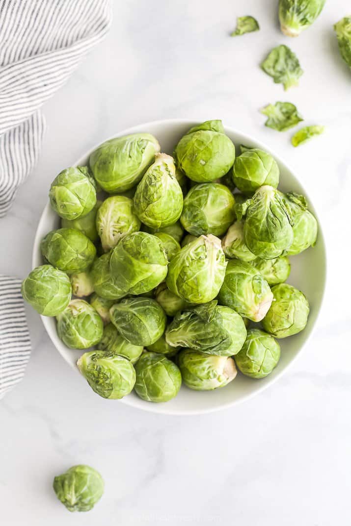 a bowl filled with raw brussel sprouts