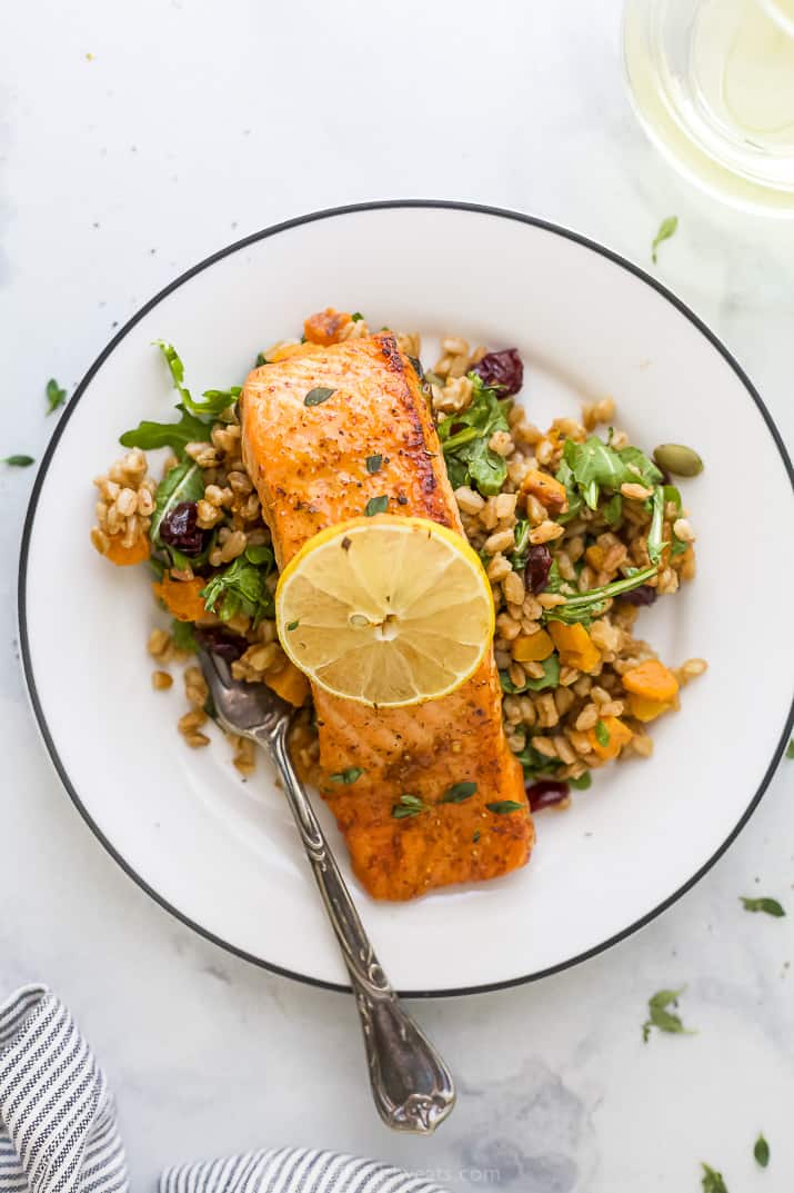 This easy 15-minute air fryer maple dijon salmon recipe makes the most flaky, tender, juicy, and delicious maple glazed salmon ever! A Salmon Filet on a Plate with a Fork and a Slice of Lemon on Top