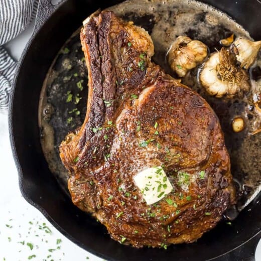 cowboy steak in a cast iron skillet with butter