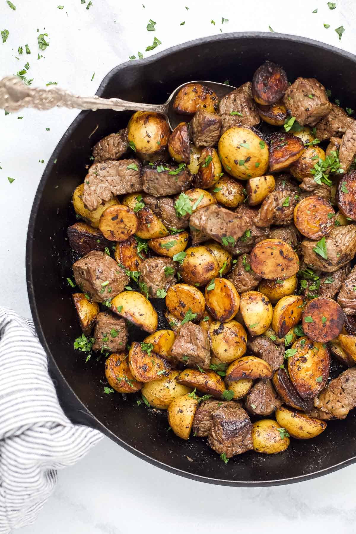 Overhead view of a garlic butter steak and potato skillet