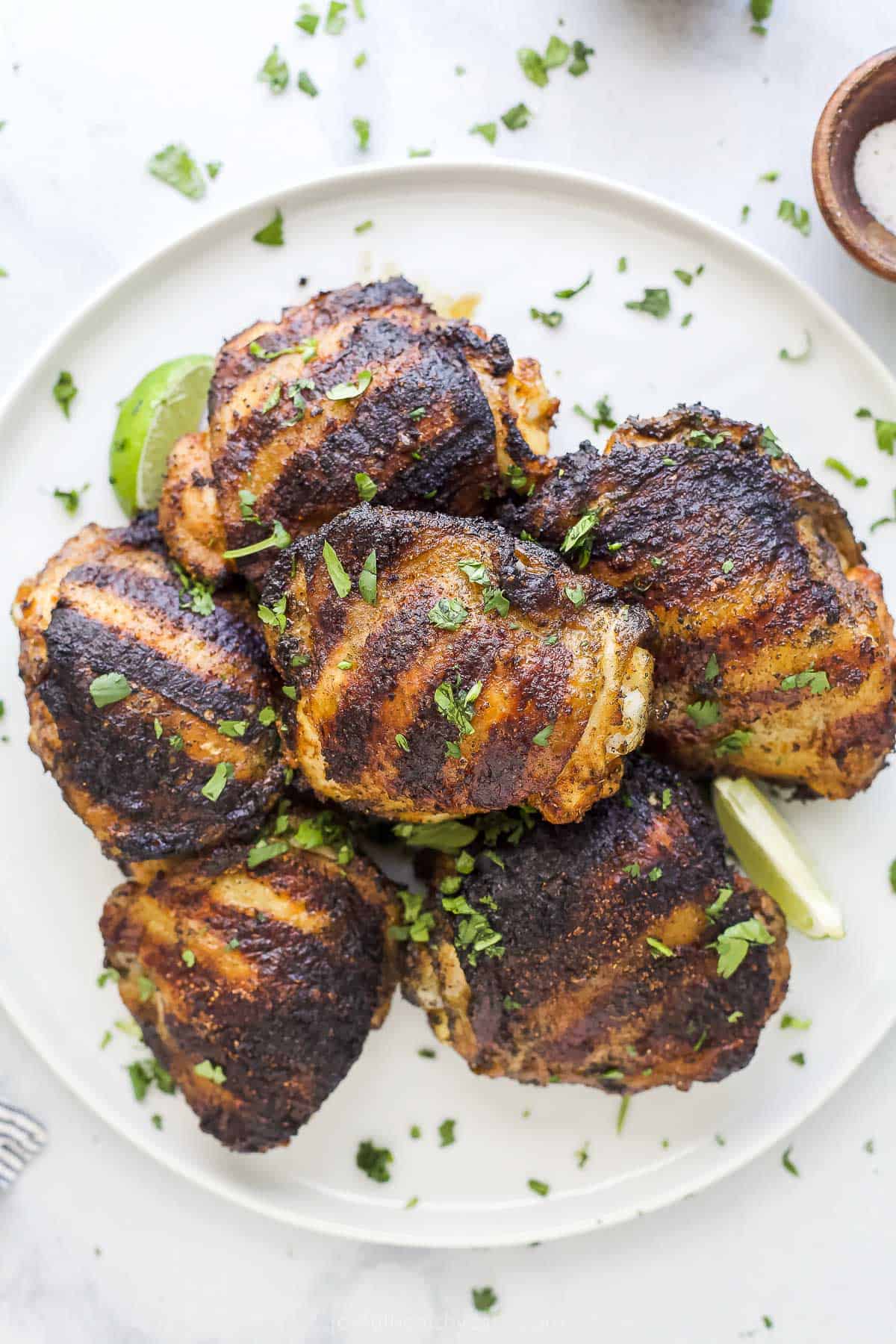 Learn how to make the best grilled chicken thighs with confidence. Tender, juicy and super flavorful every time! spice rubbed grilled chicken thighs on a plate