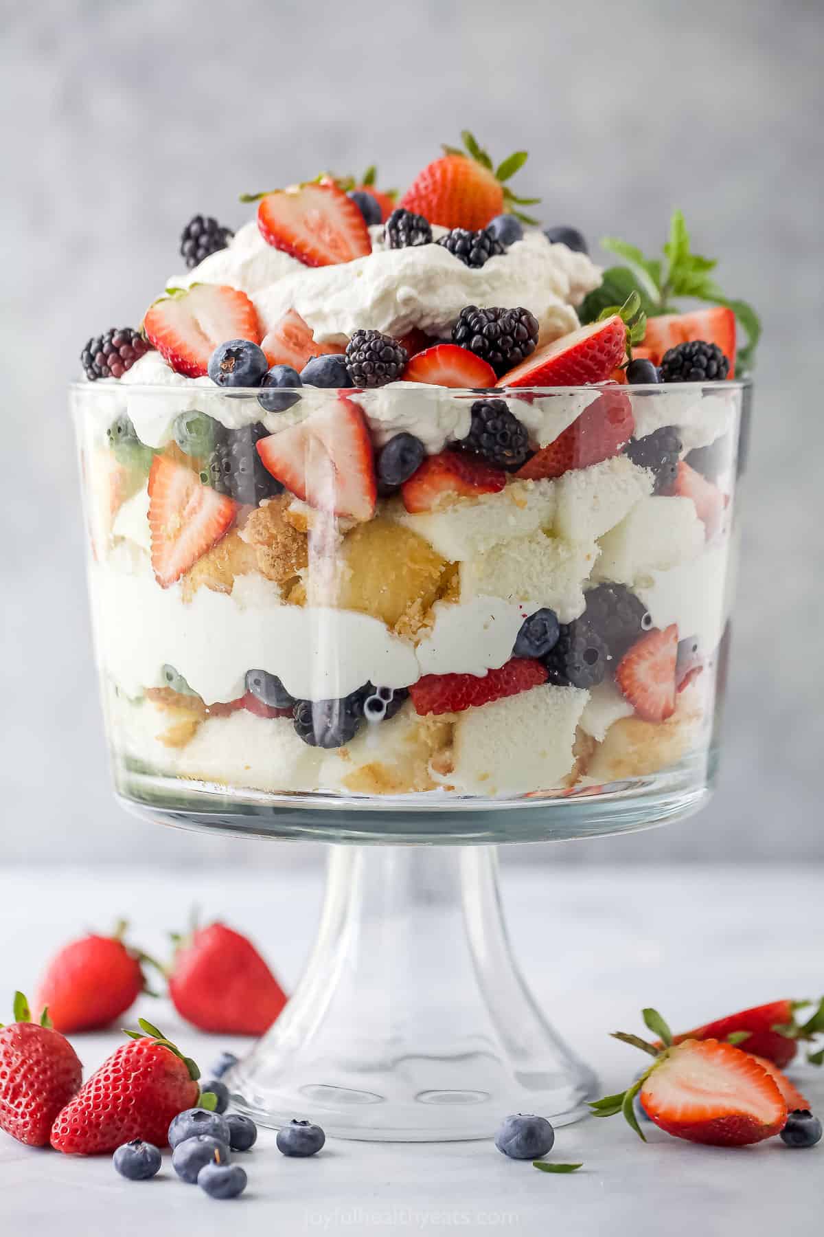 Juicy berries are layered with soft cubes of angel food cake and fluffy homemade whipped cream in this tempting Strawberry Shortcake Trifle! A layered dessert with fresh berries, angel food cake and whipped cream in a large glass container