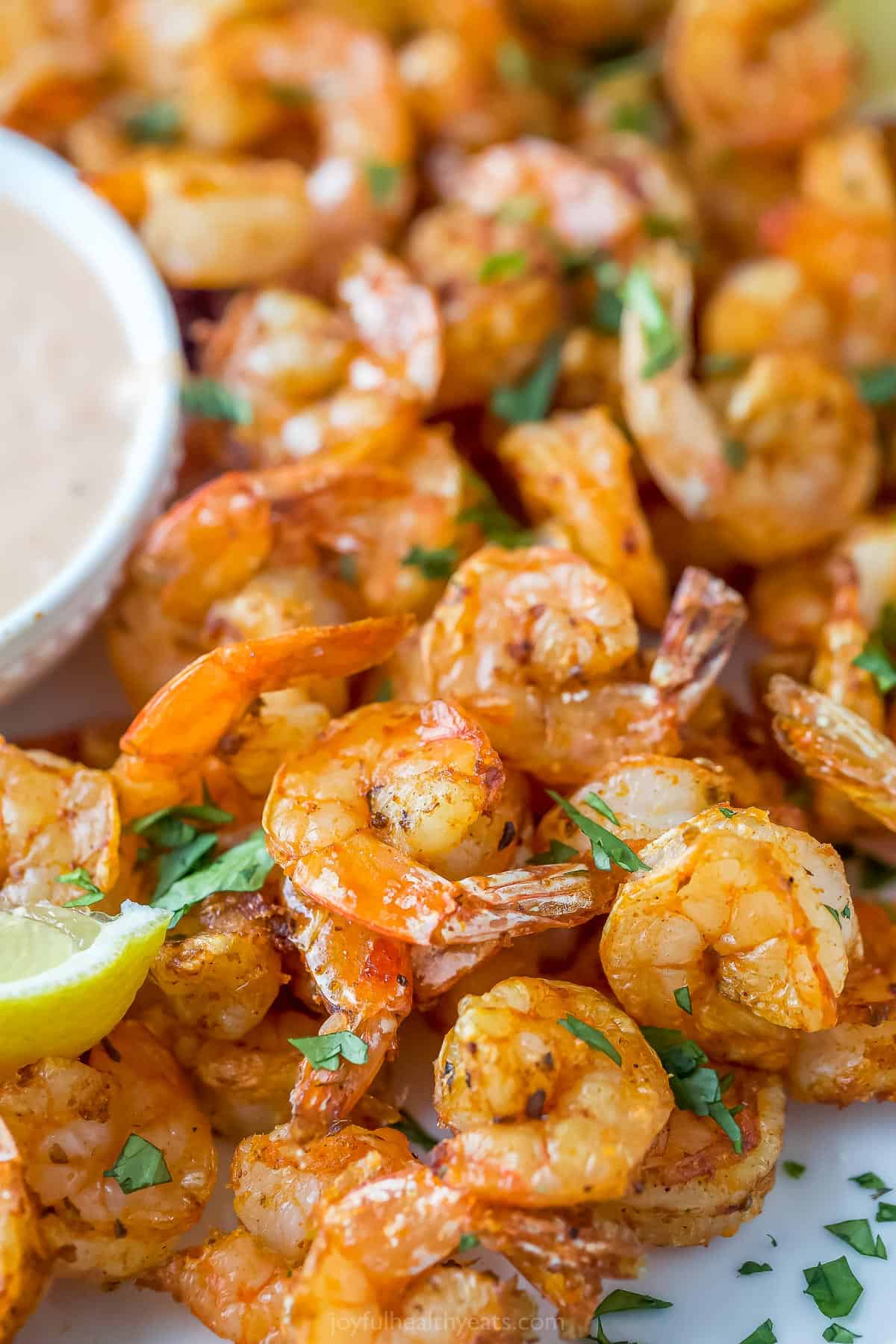 10 minute Air Fryer Shrimp is perfectly seasoned with garlic, paprika, and oregano. You can enjoy them in many different ways! close up of shrimp cooked that have been cooked in an air fryer