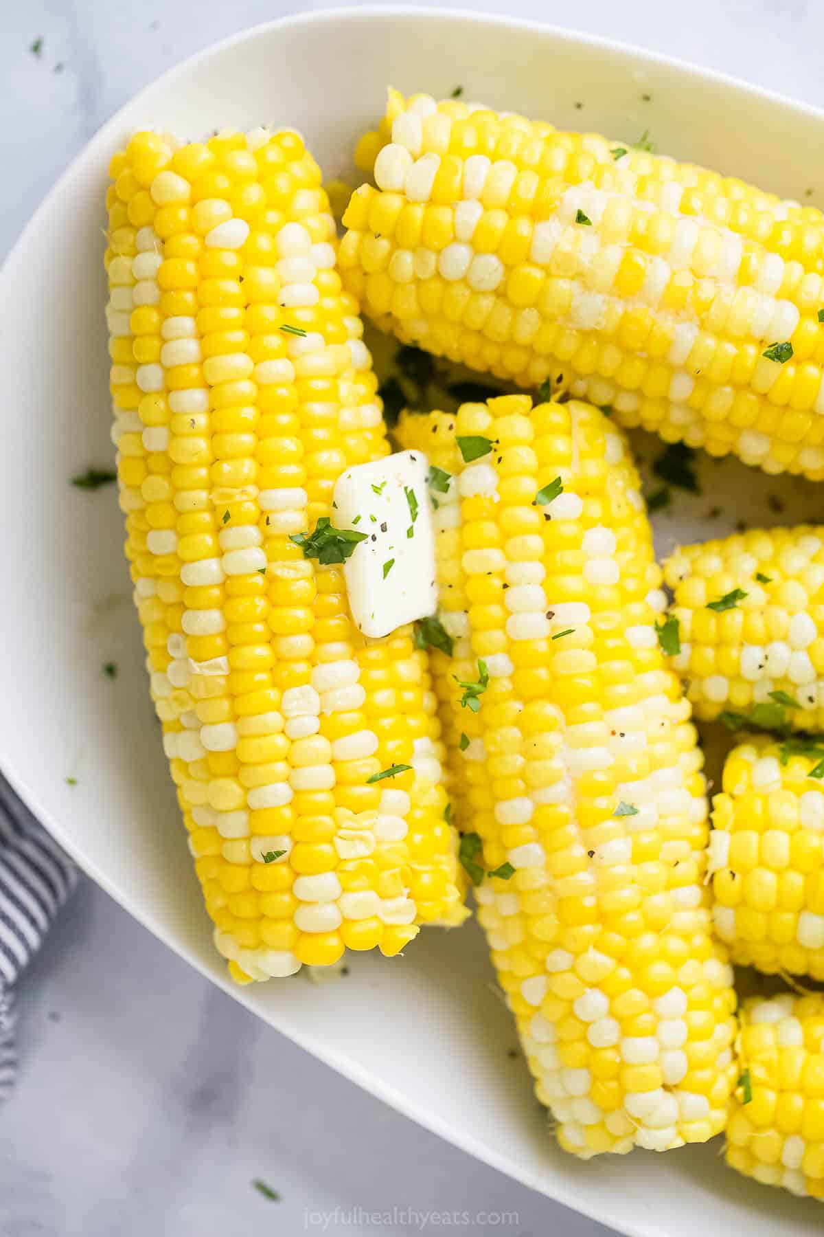 Instant Pot Corn on the Cob always comes out ultra-juicy and flavorful with no seasonings required! This speedy side dish is a game-changer. Pressure cooker corn on the cob topped with a pat of butter and a sprinkle of chopped herbs
