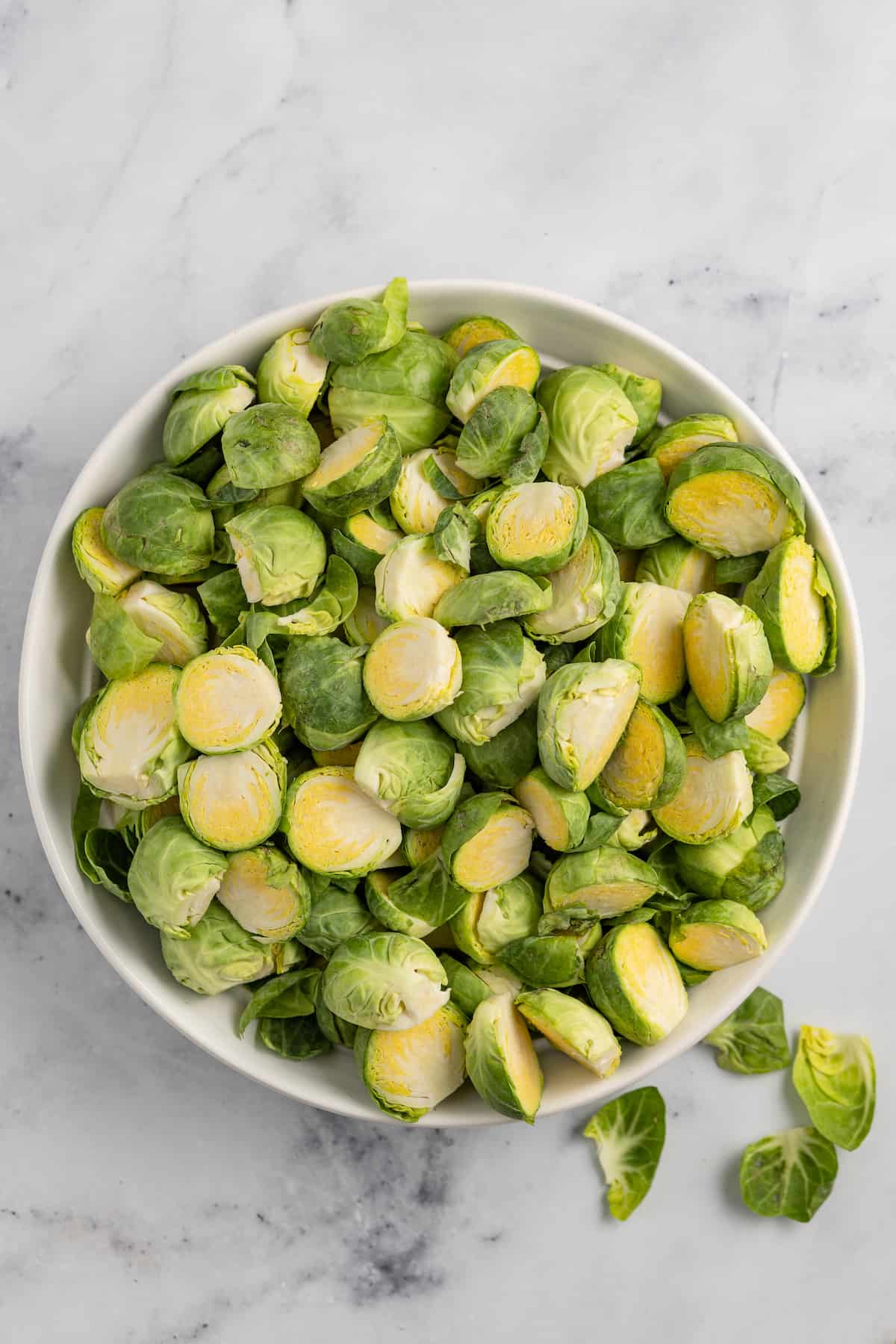 a large bowl of raw halved brussels sprouts
