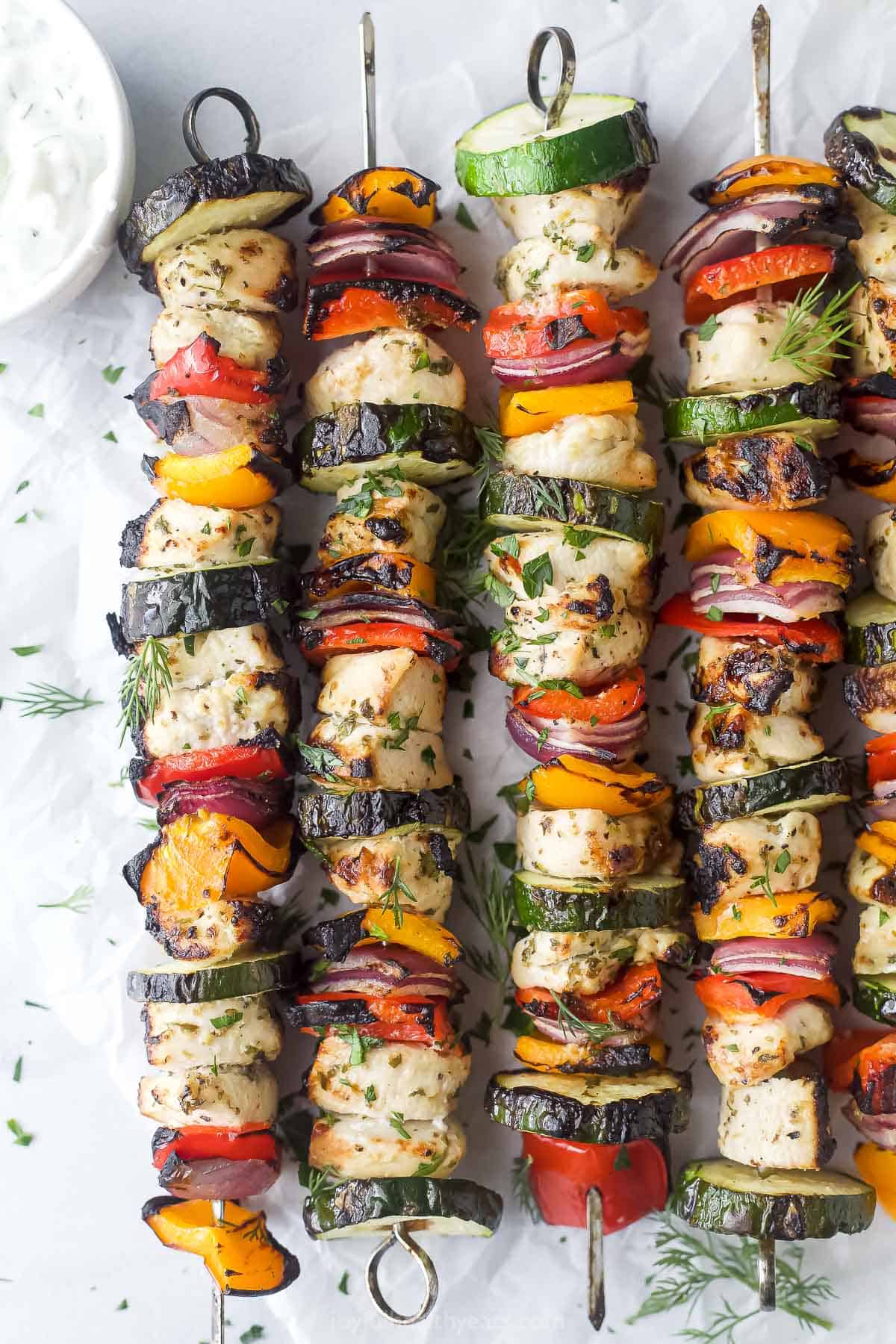 These Mediterranean chicken kabobs with homemade tzatiki come together in less than an hour for the perfect grilled summer lunch at home. Grilled Mediterranean chicken kabobs with tzatziki on the side.