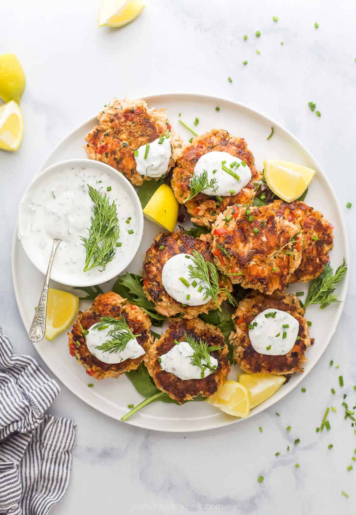 These 30-minute salmon cakes with homemade lemon dill yogurt sauce are juicy, tender, and creamy all in one. You'll love how easy they are! Salmon cakes with lemon dill sauce on the side.