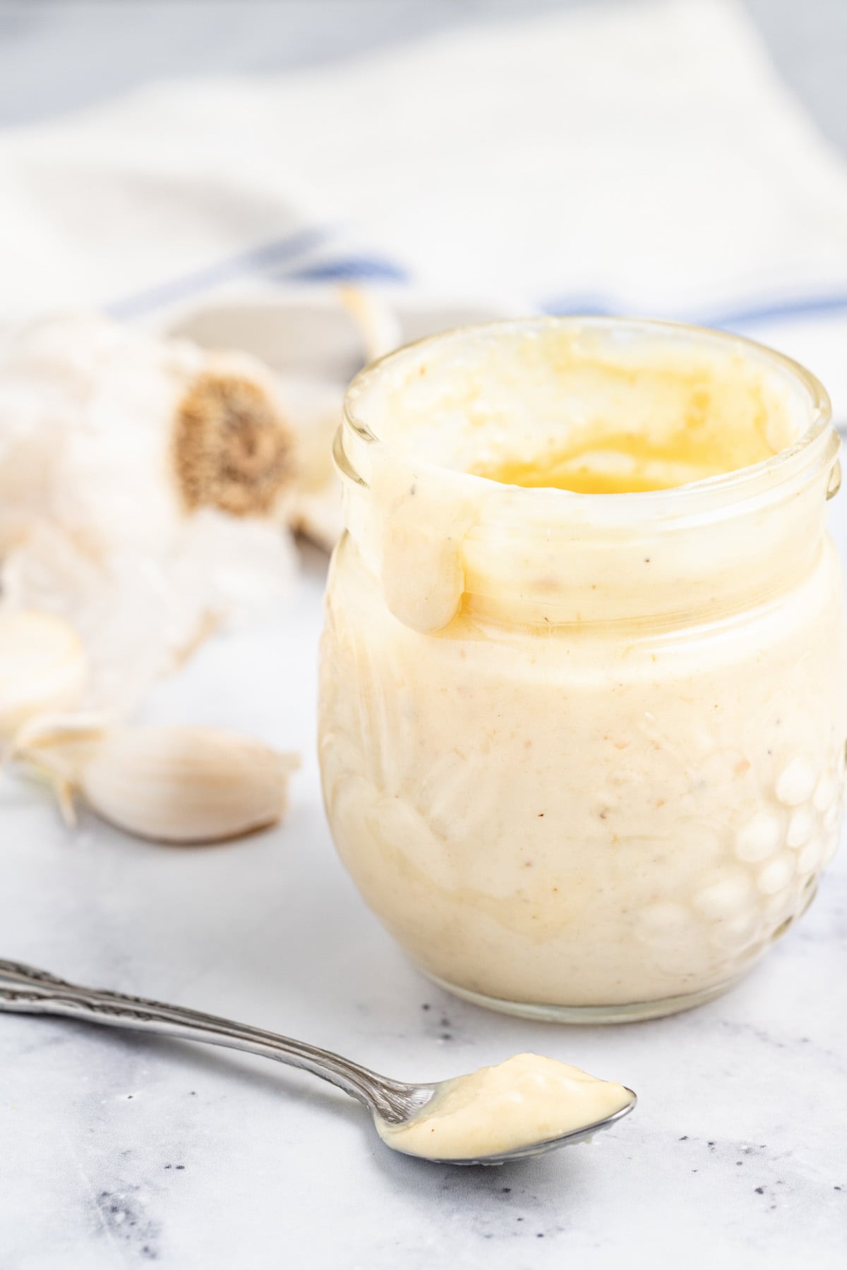This homemade garlic aioli with dijon, parmesan, and lemon juice is perfect for dipping all of your french fries into! Jar of garlic aioli.