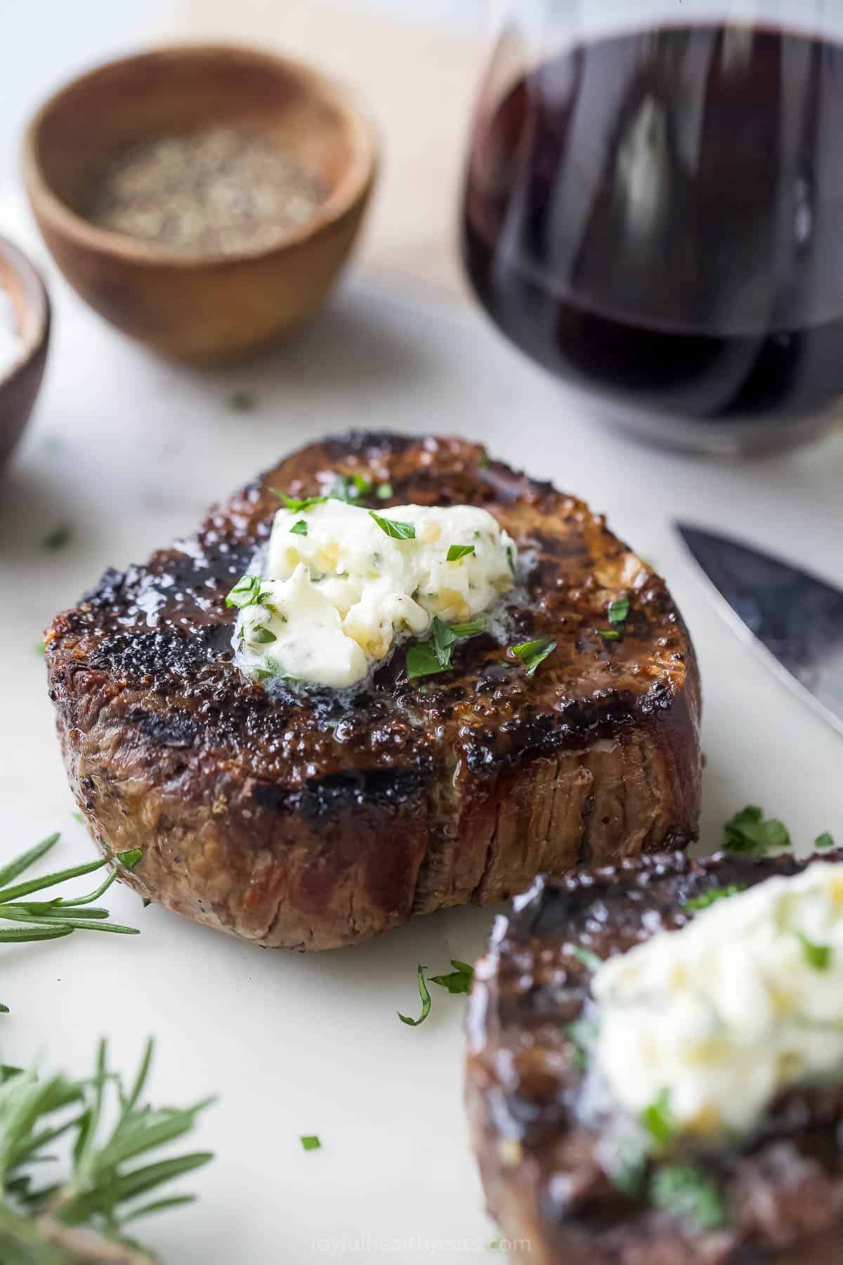 This 3-ingredient grilled filet mignon recipe is a juicy steak dinner you'll love for any weeknight or special occasions. Grilled filet mignon with a knob of butter on top.
