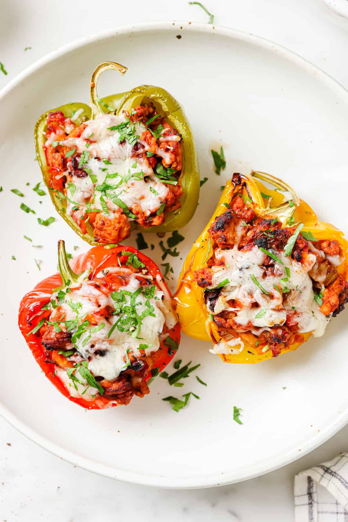 Three ground turkey stuffed peppers on a plate