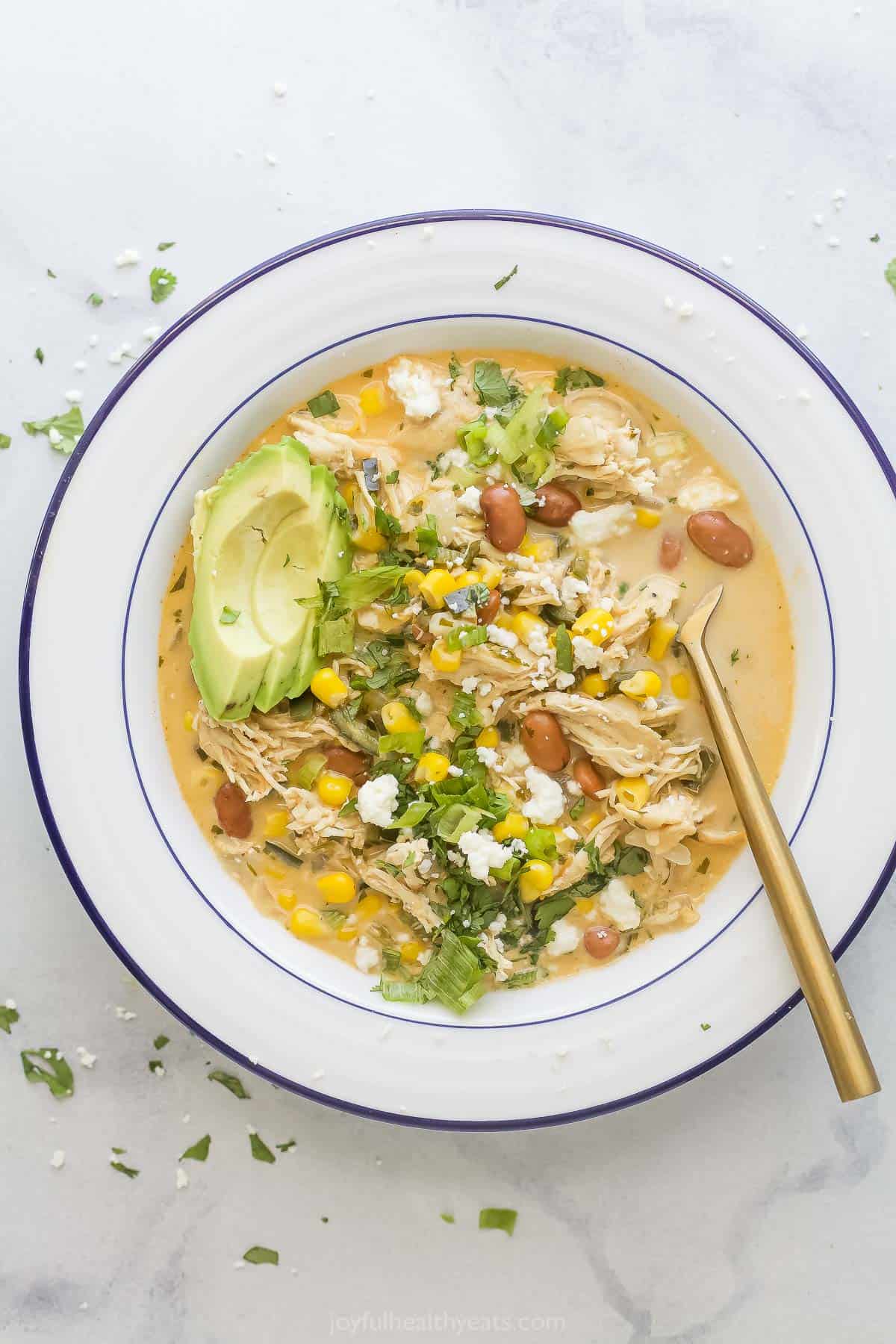 This creamy white chicken chili recipe with sweet poblanos, tender beans, and onions is a smokey, spicy dinner you'll love. Bowl of creamy white chicken chili.