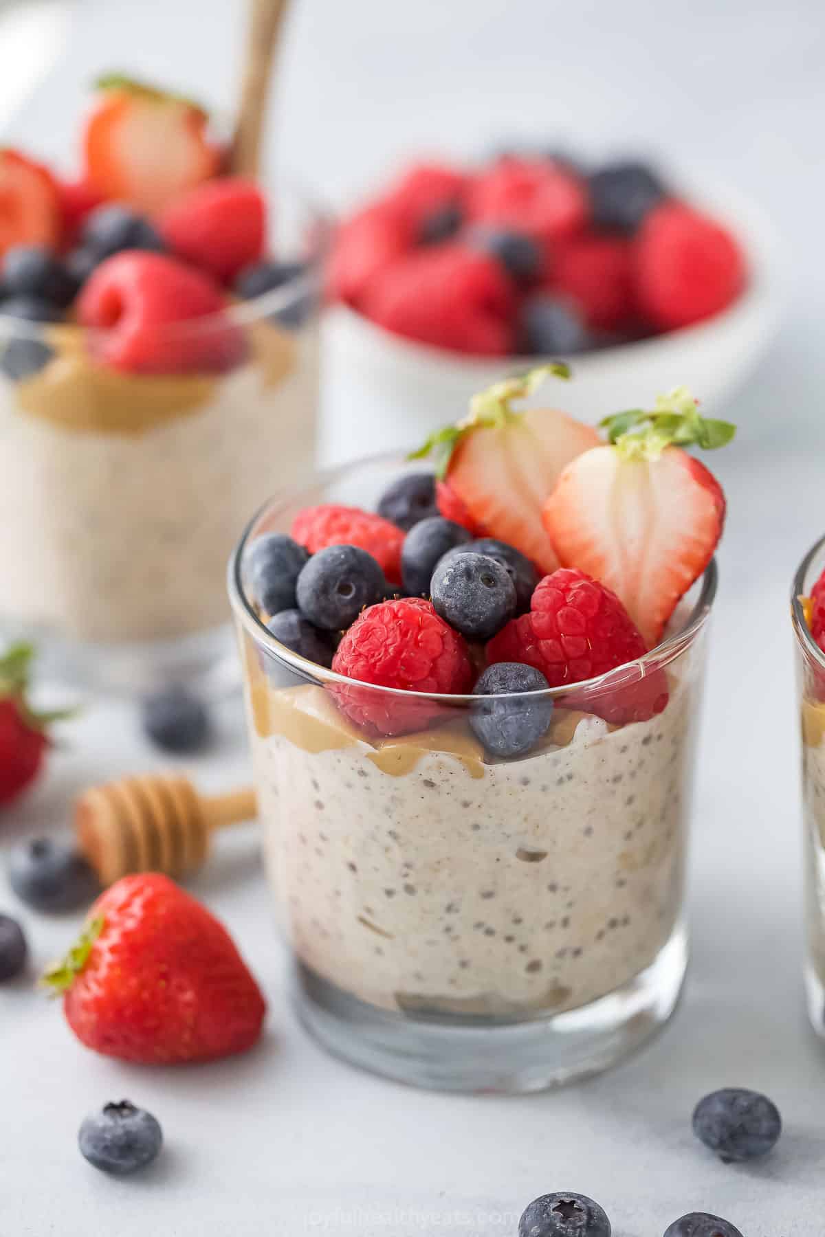 This overnight oats with yogurt recipe is a great on-the-go breakfast packed with crunchy chia, honey, and your favorite fruits as toppings. Overnight oats with yogurt in a glass with fresh berries on top.