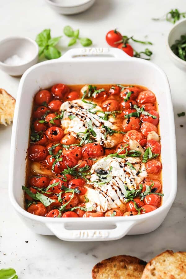 Burrata caprese with basil and balsamic reduction in the baking dish.