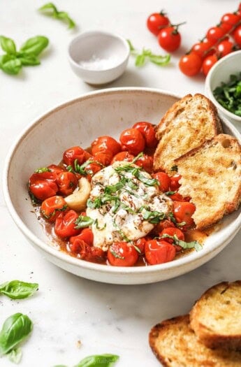 Bowl of burrata caprese with toasted sourdough and balsamic reduction.