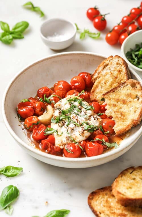 Bowl of burrata caprese with toasted sourdough and balsamic reduction.