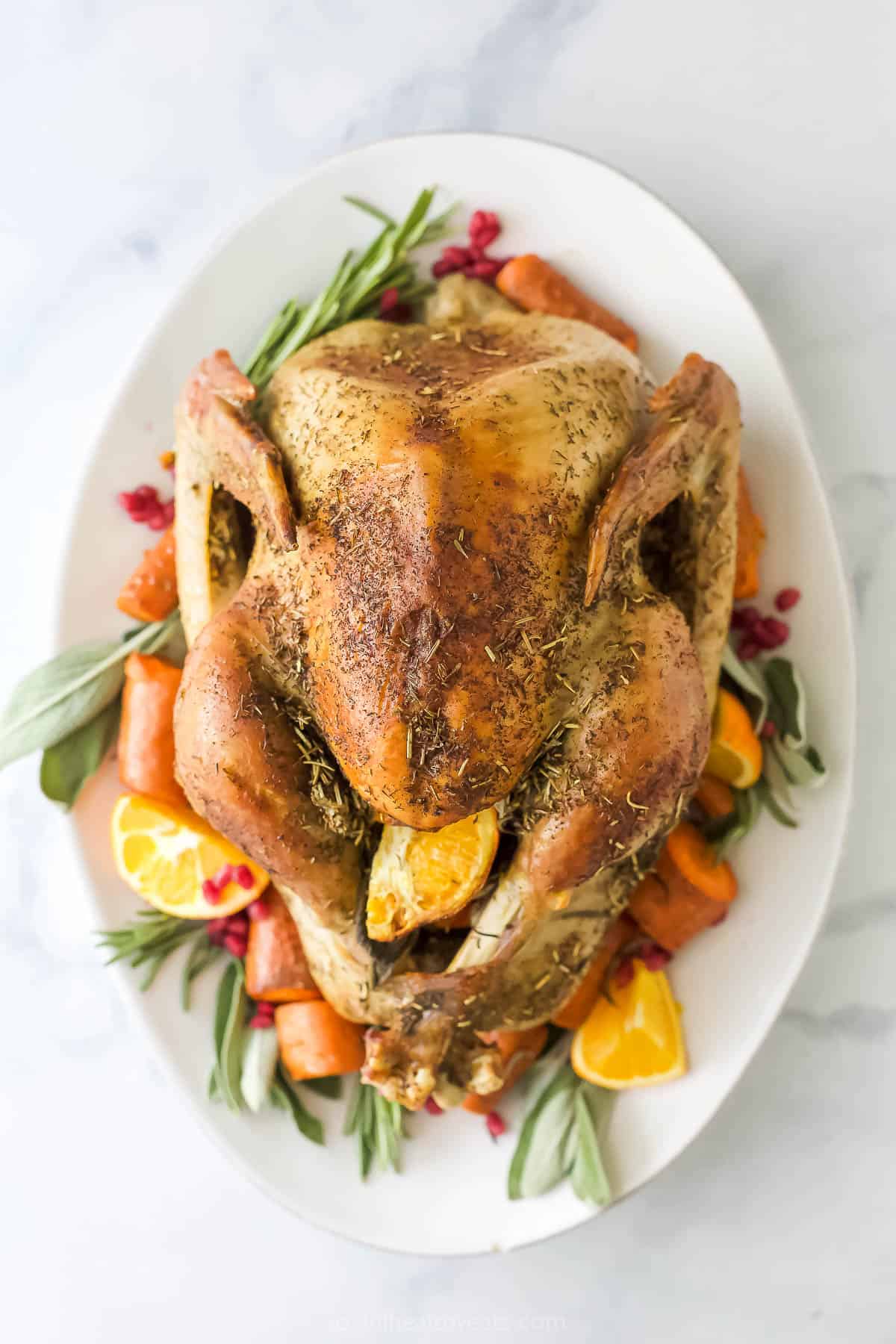 This 3-herb dry brine turkey recipe with dried rosemary, thyme, and sage will pack your holiday dinner with classic herby flavors. Roasted dry brine turkey with crispy, golden skin on a serving plate.